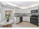Modern kitchen with white cabinets, granite countertops, and stainless steel appliances at 207 Rubens Dr # D, Nokomis, FL 34275