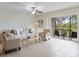 Comfortable living room with neutral colors, tile flooring, and access to a screened-in lanai at 207 Rubens Dr # D, Nokomis, FL 34275