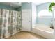 Bright bathroom showcasing a tub with shower with a decorative seashell themed shower curtain at 2091 Oakford Rd, Sarasota, FL 34240