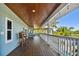 Expansive covered porch with wooden flooring and white railings at 2127 Lusitania Dr, Sarasota, FL 34231