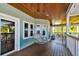 Serene covered porch with hanging chair and access to the home's interior at 2127 Lusitania Dr, Sarasota, FL 34231