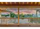 Covered deck with string lights, offering stunning sunset views over the water at 2127 Lusitania Dr, Sarasota, FL 34231