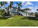 Two-story house with a large yard, palm trees, and a white staircase at 2127 Lusitania Dr, Sarasota, FL 34231