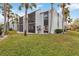 Exterior view of condo building with palm trees and lawn at 3267 Beneva Rd # 103, Sarasota, FL 34232
