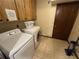 Bright laundry room with washer, dryer, and cabinets at 3455 Gardenia St, Sarasota, FL 34237