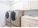 Laundry room with washer, dryer, cabinets, and a utility sink at 5131 Willow Leaf Dr, Sarasota, FL 34241