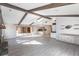 Open living area with exposed beams, stone fireplace and kitchen view at 5131 Willow Leaf Dr, Sarasota, FL 34241