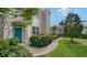 Front exterior of house with teal door and landscaped walkway at 5235 Parisienne Pl # 101B28, Sarasota, FL 34238