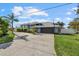 Exterior view of the home with a circular driveway and landscaping at 609 Elba Dr, Nokomis, FL 34275