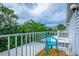 Balcony features tropical trees, a bright blue chair, light colored wood, and white railings at 6250 Holmes Blvd # 32, Holmes Beach, FL 34217