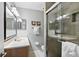 Modern bathroom featuring dual sinks, tiled shower with glass door, neutral colors and vanity lighting at 6250 Holmes Blvd # 32, Holmes Beach, FL 34217