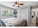 This bright bedroom has a mounted TV, double closets, ceiling fan, and a seashell themed comforter at 6250 Holmes Blvd # 32, Holmes Beach, FL 34217