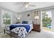 Light-filled bedroom with balcony access, ceiling fan, nautical décor, and bright blue accents at 6250 Holmes Blvd # 32, Holmes Beach, FL 34217