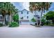 Two-story light gray beach home with a two-car garage and tropical landscaping at 6250 Holmes Blvd # 32, Holmes Beach, FL 34217