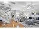 Bright living room featuring hardwood floors, a staircase, and modern ceiling fans creating an airy atmosphere at 6250 Holmes Blvd # 32, Holmes Beach, FL 34217