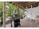 Outdoor kitchen features a stainless steel grill with wooden deck, adjacent to an enclosed outdoor shower at 6250 Holmes Blvd # 32, Holmes Beach, FL 34217