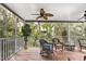 Enjoy the serene view from the screened porch featuring wicker furniture, a ceiling fan, and beautiful lush plants at 6250 Holmes Blvd # 32, Holmes Beach, FL 34217