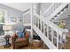 Light-filled entryway showcases a staircase, a cozy reading nook with chair and coastal decor, adding charm at 6250 Holmes Blvd # 32, Holmes Beach, FL 34217