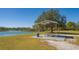 Outdoor picnic area featuring covered table, trash can, grassy field and a waterfront view near walking path at 6305 Royal Tern Cir, Lakewood Ranch, FL 34202