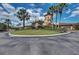Community clubhouse with palm trees and circular driveway at 7005 River Hammock Dr # 103, Bradenton, FL 34212
