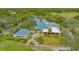 Aerial view of community clubhouse featuring manicured grounds, golf course, and lake views at 7112 Saint Johns Way, University Park, FL 34201