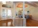 Open dining room with hardwood floors, white columns and an elegant chandelier at 805 Riviera Dunes Way, Palmetto, FL 34221