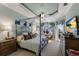 Main bedroom with canopy bed, water views, and private access to balcony at 805 Riviera Dunes Way, Palmetto, FL 34221