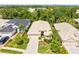 Aerial view of the home showing the beige tile roof, a well maintained lawn and mature landscaping at 8412 Whispering Woods Ct, Lakewood Ranch, FL 34202