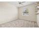 A bright bedroom with plush carpet, a window and built in shelving at 8412 Whispering Woods Ct, Lakewood Ranch, FL 34202