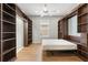 Spacious bedroom showcasing hardwood floors, a ceiling fan, built-in bookshelves and a pull-down bed at 8412 Whispering Woods Ct, Lakewood Ranch, FL 34202