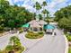A gated community entrance with palm trees, manicured landscaping, and a guard house to control access at 8412 Whispering Woods Ct, Lakewood Ranch, FL 34202