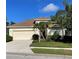 Charming single-story home featuring a well-manicured lawn and a two-car garage at 8412 Whispering Woods Ct, Lakewood Ranch, FL 34202