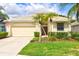 Lovely single-story home with a red front door, well-kept lawn, and a two-car garage at 8412 Whispering Woods Ct, Lakewood Ranch, FL 34202