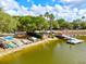 A serene lake view with colorful boats, a wooden bridge, and lush trees, creating a tranquil atmosphere at 8412 Whispering Woods Ct, Lakewood Ranch, FL 34202