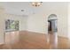 Open living room featuring beautiful hardwood floors, a ceiling fan, and sliding glass doors to the lanai at 8412 Whispering Woods Ct, Lakewood Ranch, FL 34202