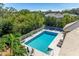 An aerial shot features a large in-ground swimming pool surrounded by a white fence and lush green trees at 8412 Whispering Woods Ct, Lakewood Ranch, FL 34202