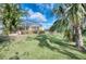Landscaped backyard with lush lawn and tropical plants at 9351 Raes Creek Pl, Palmetto, FL 34221