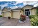 House exterior with three car garage and manicured landscaping at 9351 Raes Creek Pl, Palmetto, FL 34221