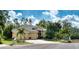 Yellow house with three-car garage and palm trees at 9351 Raes Creek Pl, Palmetto, FL 34221