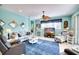 Living room with light blue walls, comfy seating, and a large TV at 9351 Raes Creek Pl, Palmetto, FL 34221