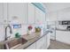 Bright kitchen featuring white cabinets, stone countertops, and stainless steel sink at 104 23Rd St, Bradenton Beach, FL 34217