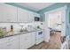 Bright kitchen featuring white cabinets, subway tile backsplash, granite countertops, and a view into the living room at 104 23Rd St, Bradenton Beach, FL 34217