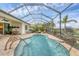 Enclosed lanai with kidney-shaped pool and paver deck at 10828 Trophy Dr, Englewood, FL 34223