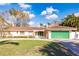 Single-story home with a terracotta tile roof, green garage door, and landscaped lawn at 1397 Harbor Dr, Sarasota, FL 34239