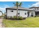 Back of house with covered patio, landscaping, and grassy yard at 16714 Savory Mist Cir, Bradenton, FL 34211