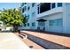 Brick patio with seating and umbrella, steps leading to waterfront walkway at 174 Golden Gate Pt # 21, Sarasota, FL 34236