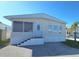 Tan mobile home with white trim, steps, and railing. Situated in a mobile home community at 3333 26Th E Ave # 1148, Bradenton, FL 34208