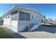 Side view of a tan mobile home with white trim and steps. Shows the home's length and features at 3333 26Th E Ave # 1148, Bradenton, FL 34208