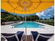 Inviting pool area with lounge chairs and yellow umbrella at 3427 Winding Oaks Dr # 14, Longboat Key, FL 34228