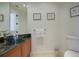 Chic powder room features dark vessel sink, granite countertop, and wood cabinets at 4125 Gulf Of Mexico Dr # S201, Longboat Key, FL 34228